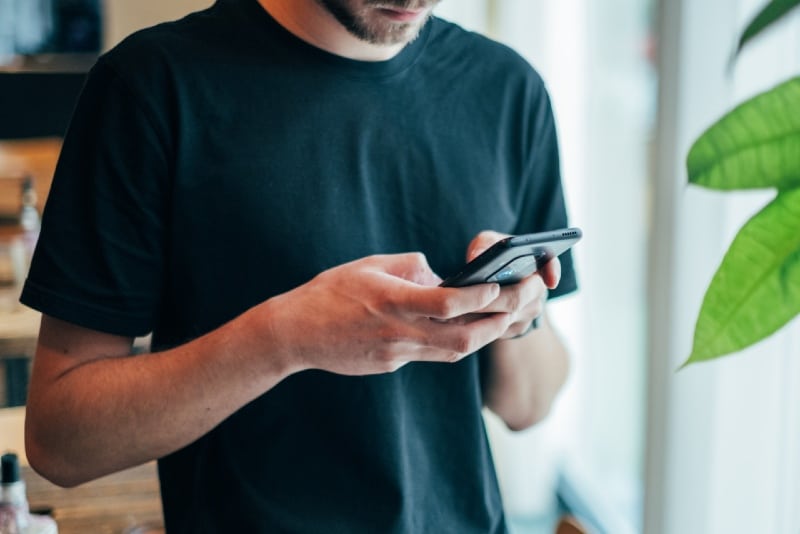 man in black shirt using smartphone
