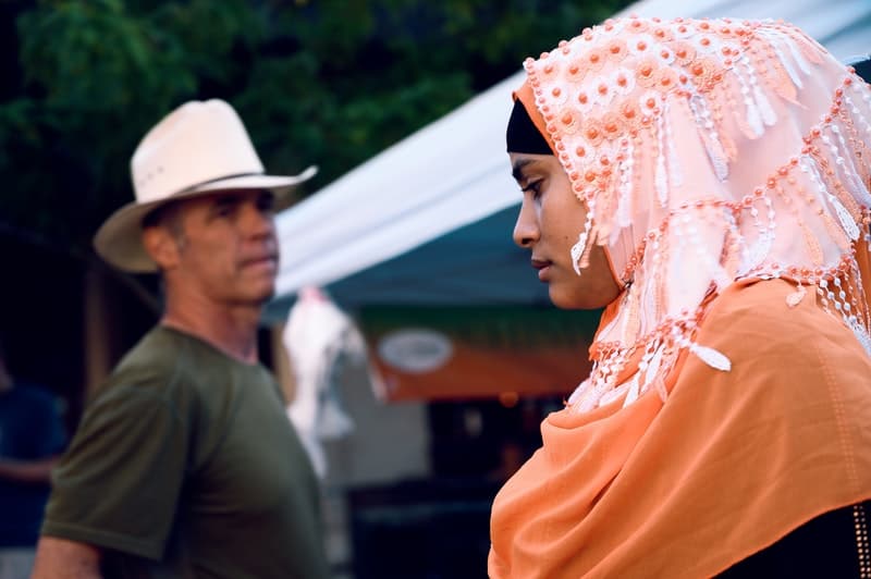 man wearing a cowboy hat looking at a woman