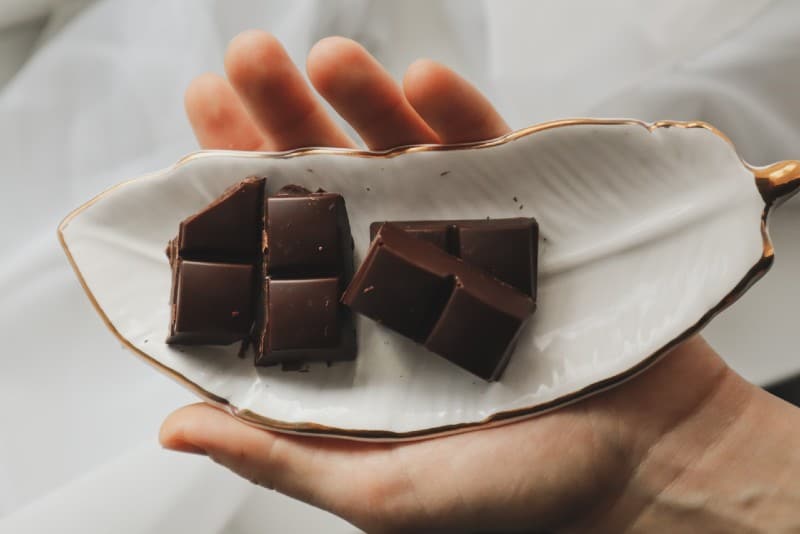 uomo con in mano un piatto con barrette di cioccolato