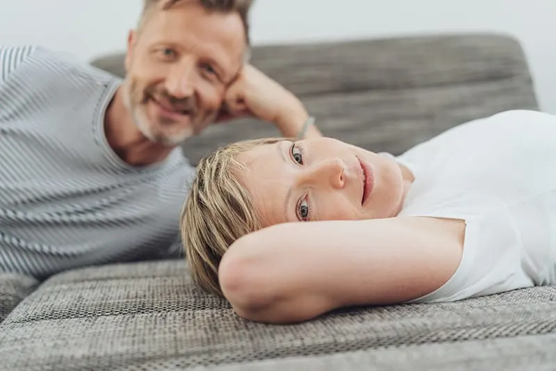 Man propped on elbows woman lying down with arm as pillow