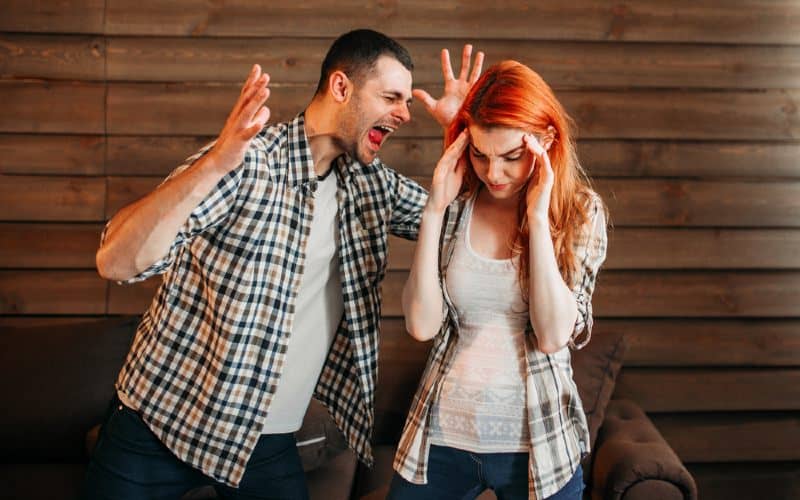 Angry man yelling at scared woman