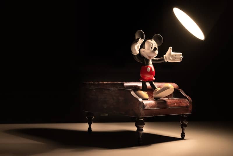 mickey mouse on piano with a lamp light focused on him