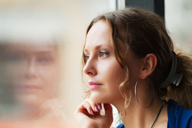 mindful woman staring at distance through the window
