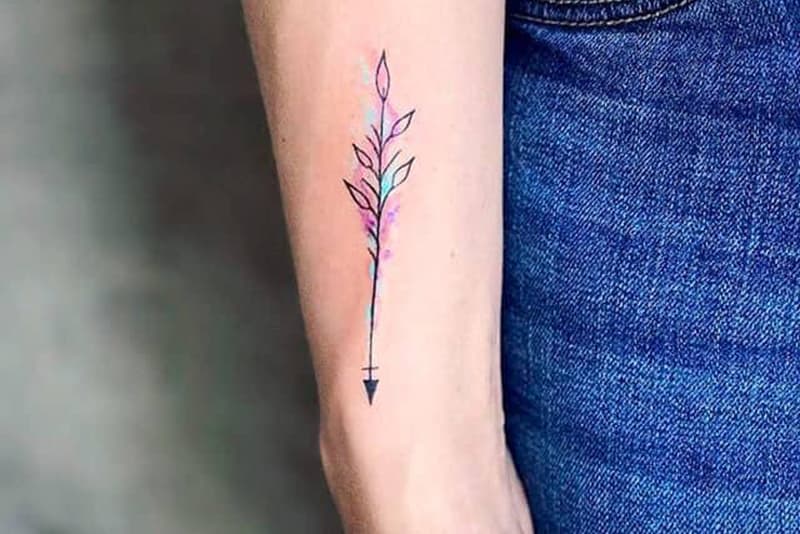 tatuagem de seta minimalista a cores no pulso