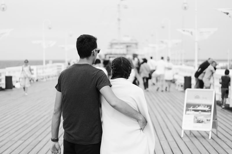 Casal monocromático homem abraça mulher no passeio marítimo