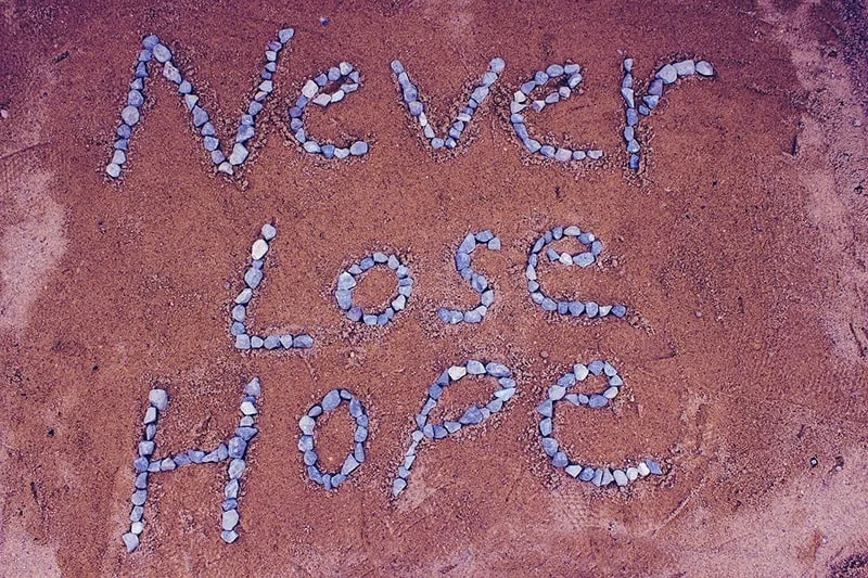 never lost hope quote made with stones on brown background