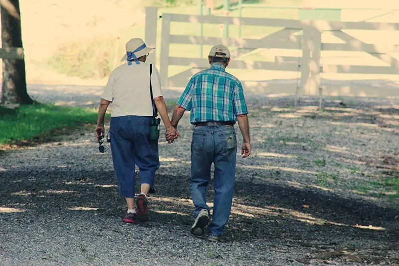 old couple walking whole holding hands