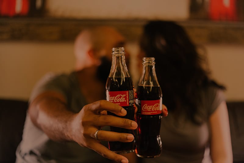 people holding coca-cola bottles in front of them