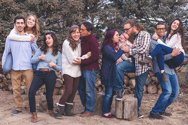 people standing in front of wood pile while posing for photography