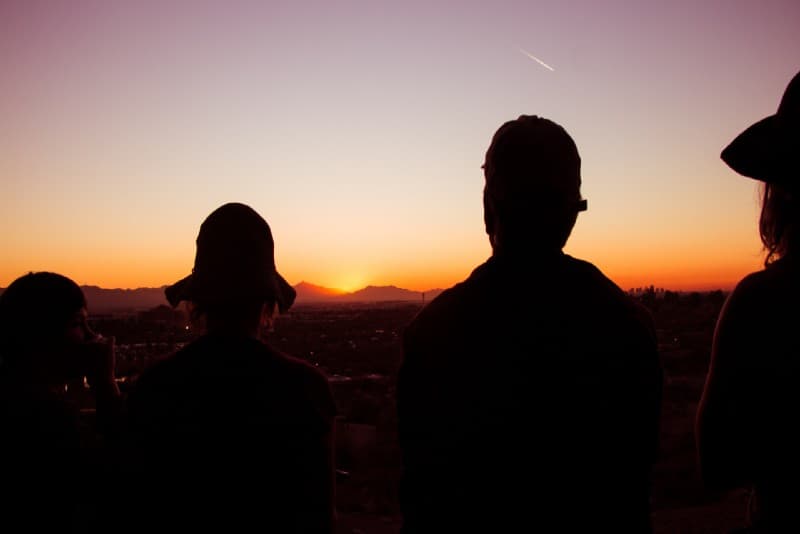 four people watching sunset at roof top