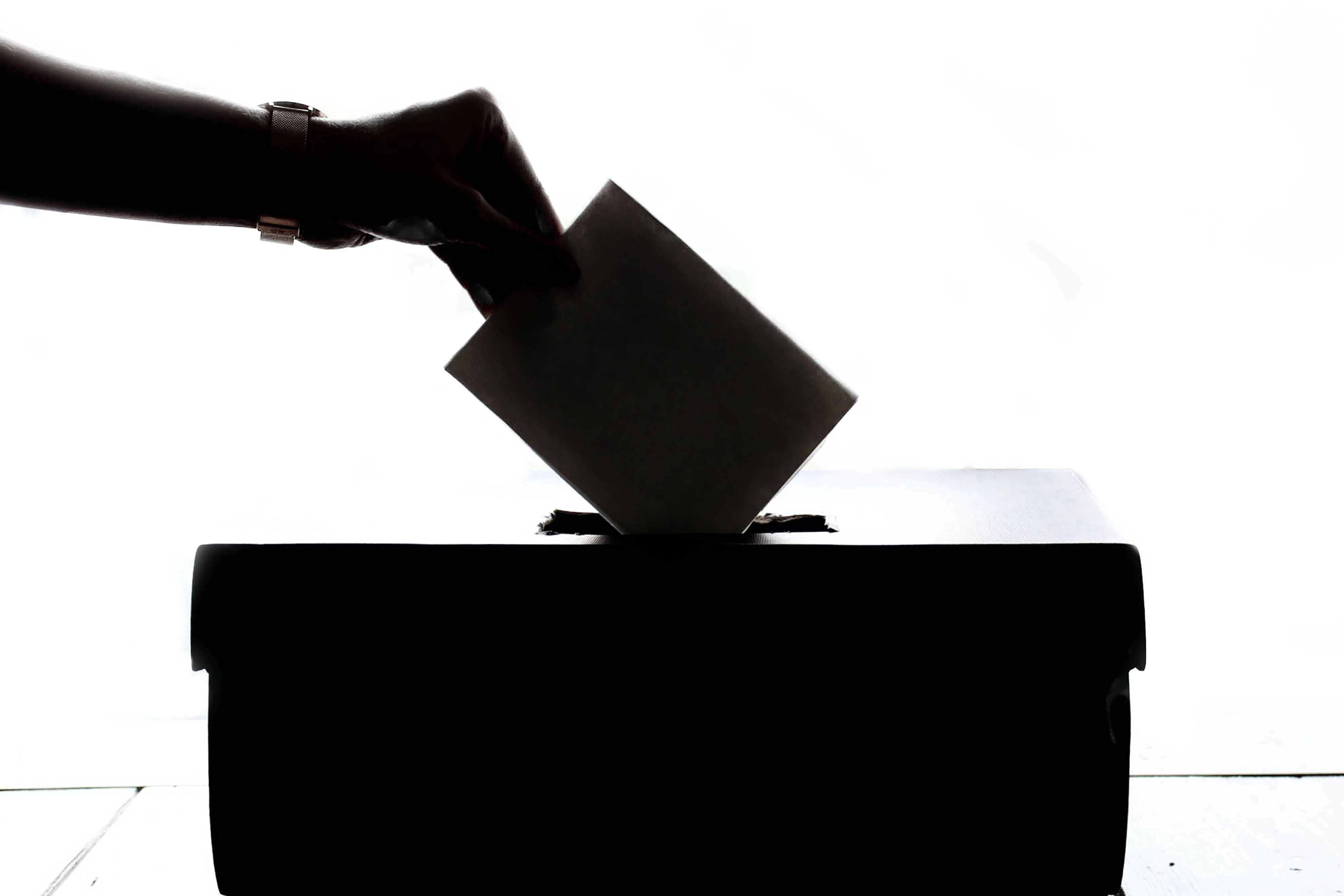 person dropping paper in the box
