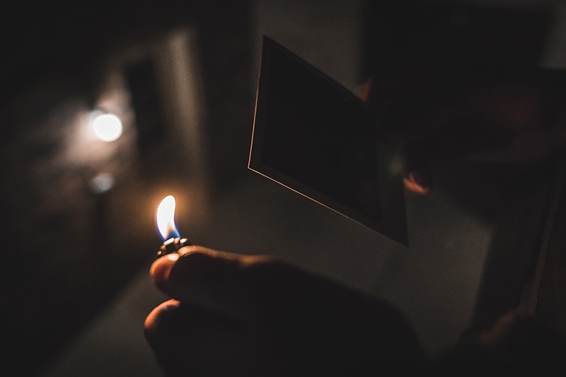 person holding a lighter near the photography