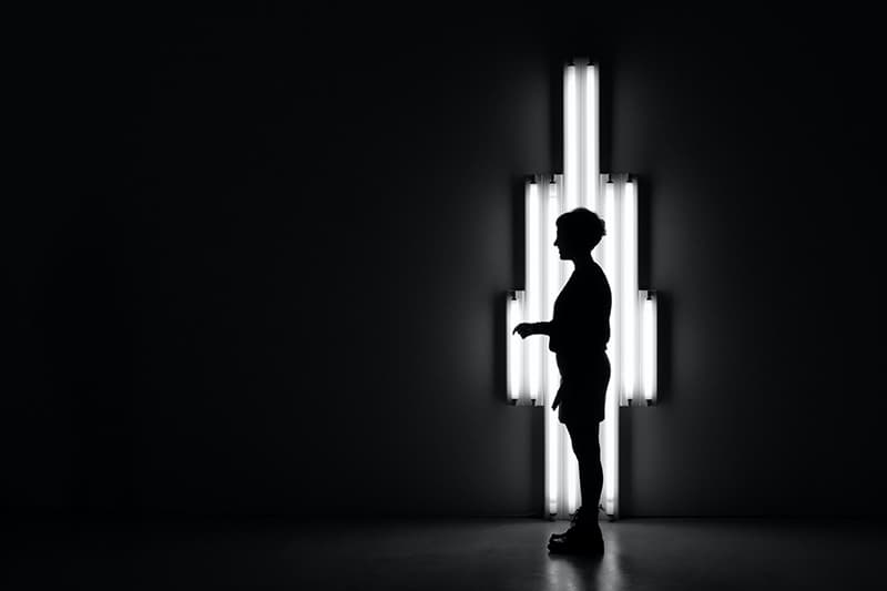 persona in piedi al buio davanti a una lampada