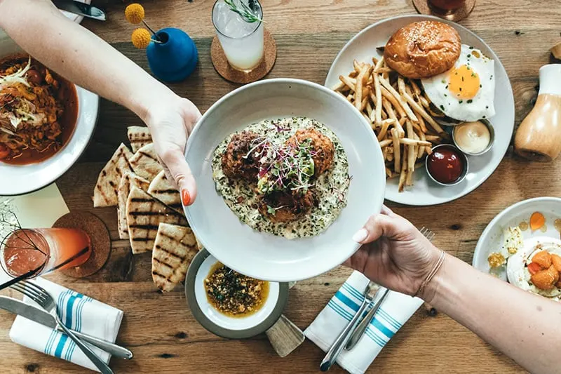 persons holding white plate with food