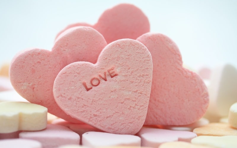 Cuori di caramelle rosa con una scritta d'amore su uno di essi
