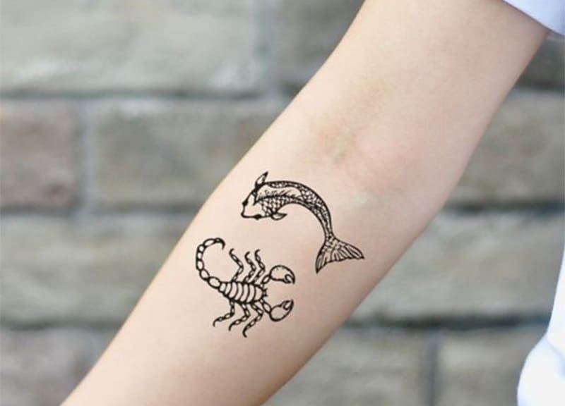 pisces and scorpio tattoo on the arm
