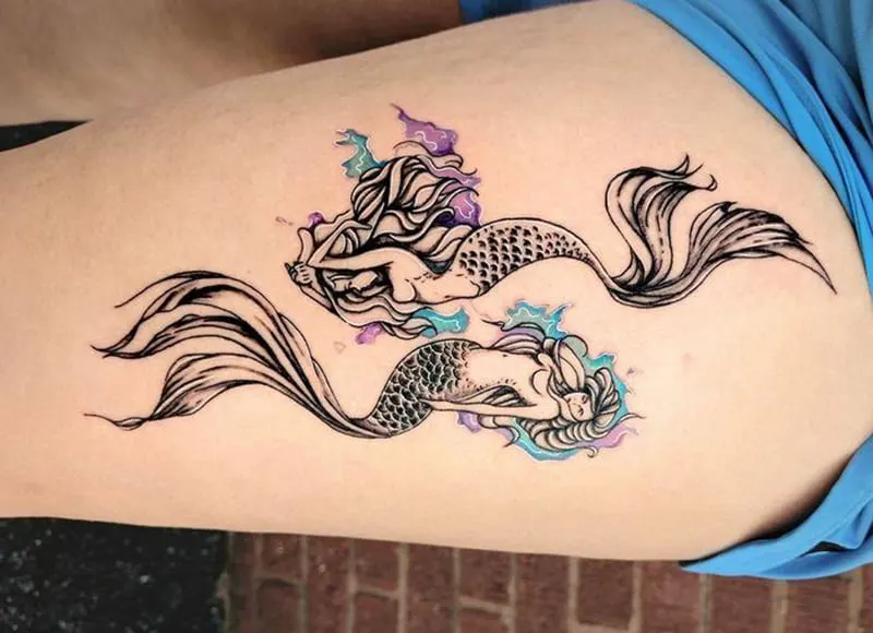 pisces tattoo as mermaids on the thigh