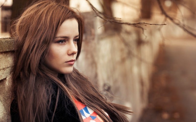 Portrait of a beautiful girl sitting outdoors during daytime