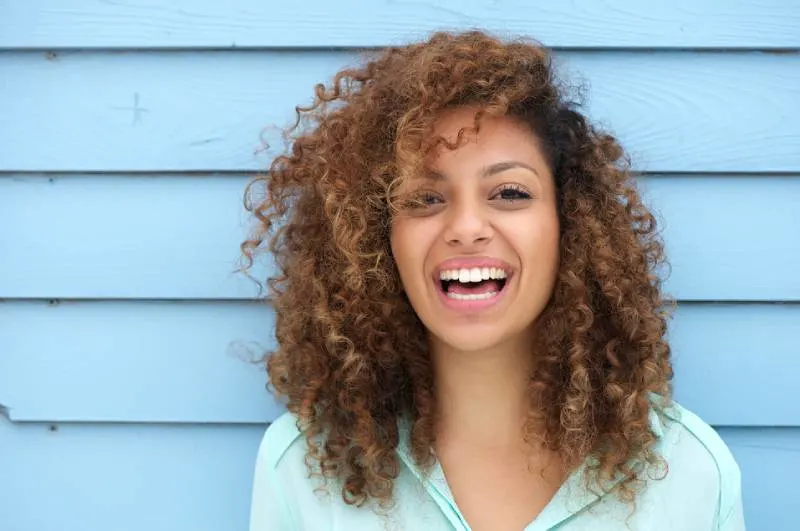portrait of young smiling woman with curly hair