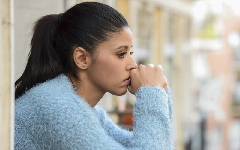 profile of young beautiful hispanic woman wearing blue top