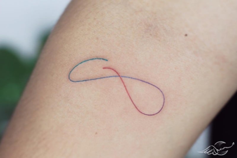 tatuaggio con segno del filo arcobaleno sul braccio