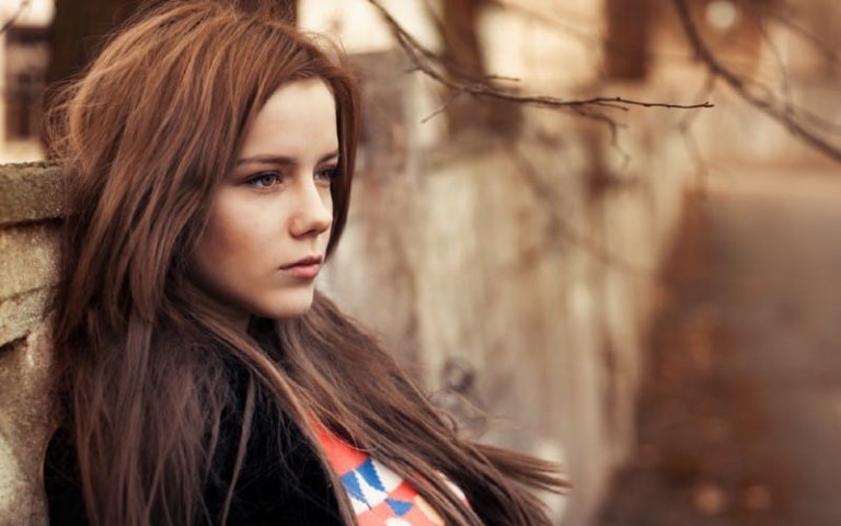 Sad woman sitting outdoors during daytime