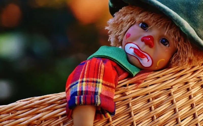 Sad clown doll in a basket