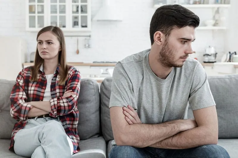 sad couple in argue sitting on the couch