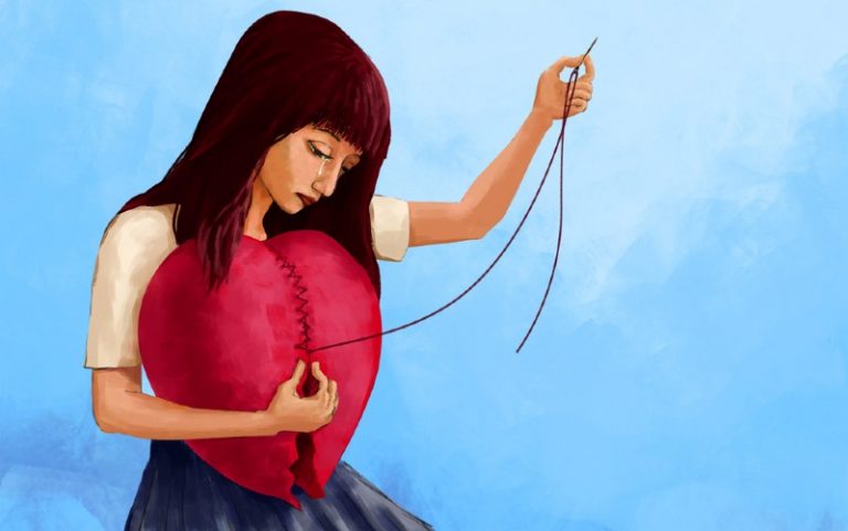Sad wooman sewing a big red heart