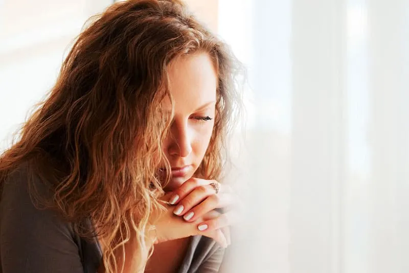 sad mindful woman looking at floor