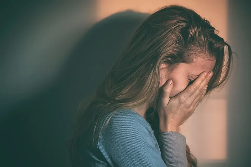 sad woman crying with hands on the face
