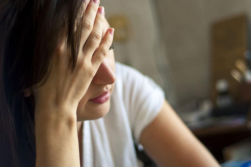 mulher triste com uma dor de cabeça