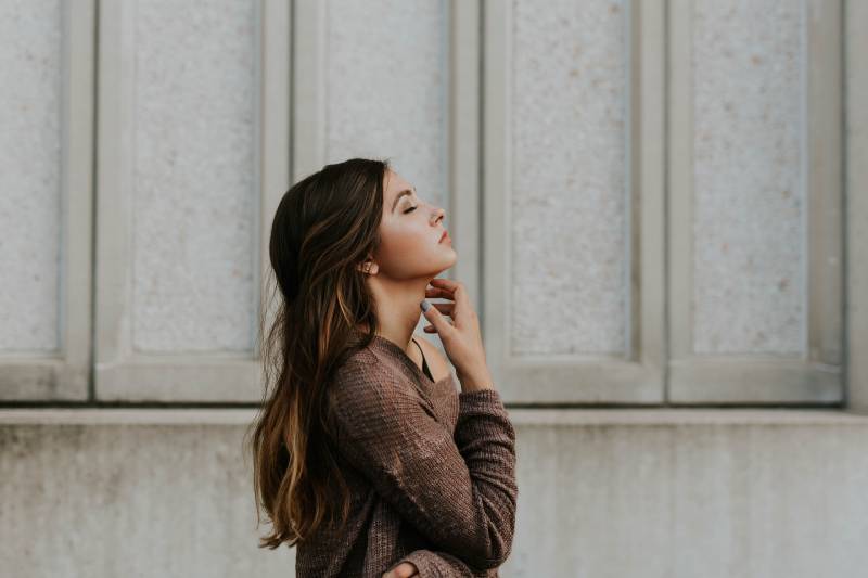 side view of woman with closed eyes and looking up