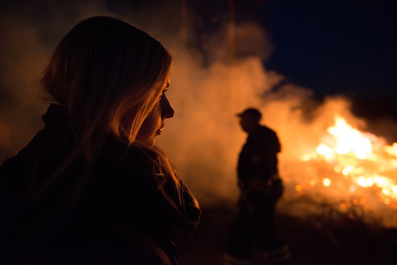 sagoma di uomo e donna nelle vicinanze di un incendio nella boscaglia