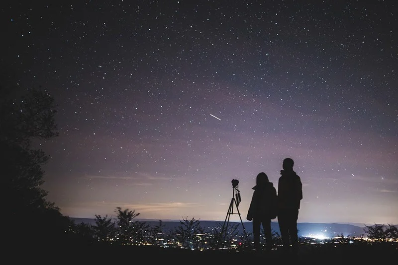 silhouette of two person standing during nightime