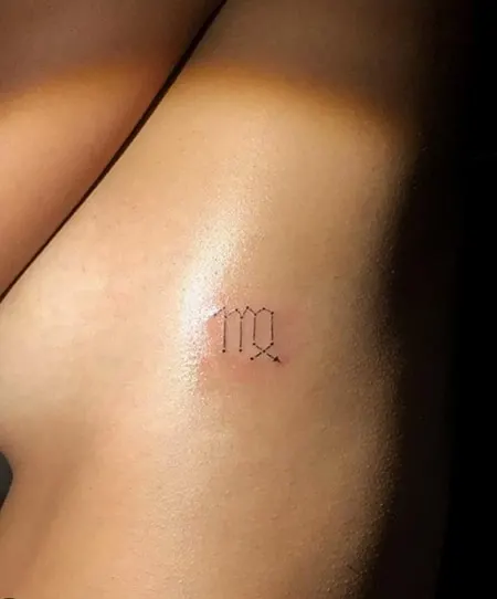 simple Virgo zodiac symbol tattoo on side of the rib