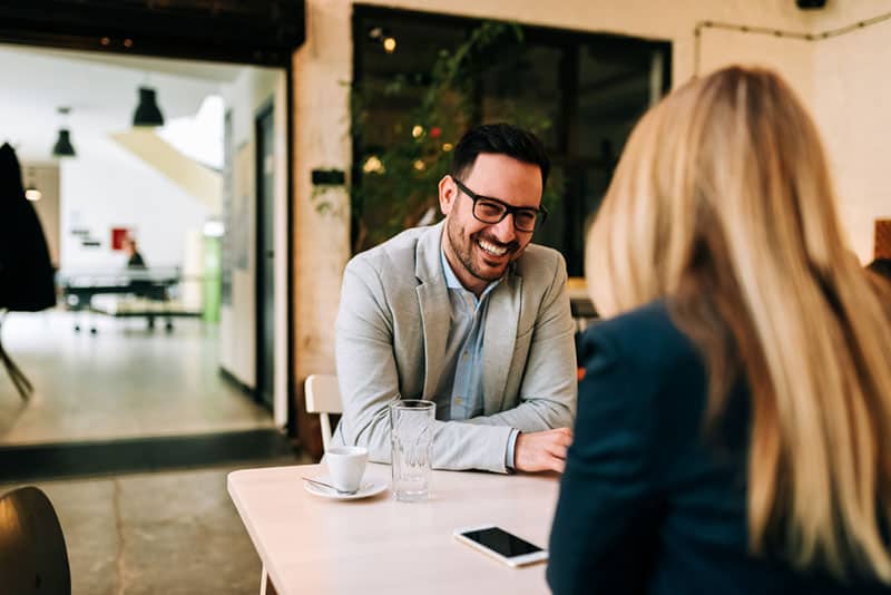 smiling man talking to woman