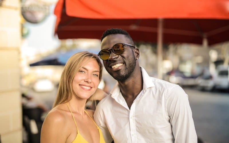 Uomo sorridente con donna per strada durante il giorno