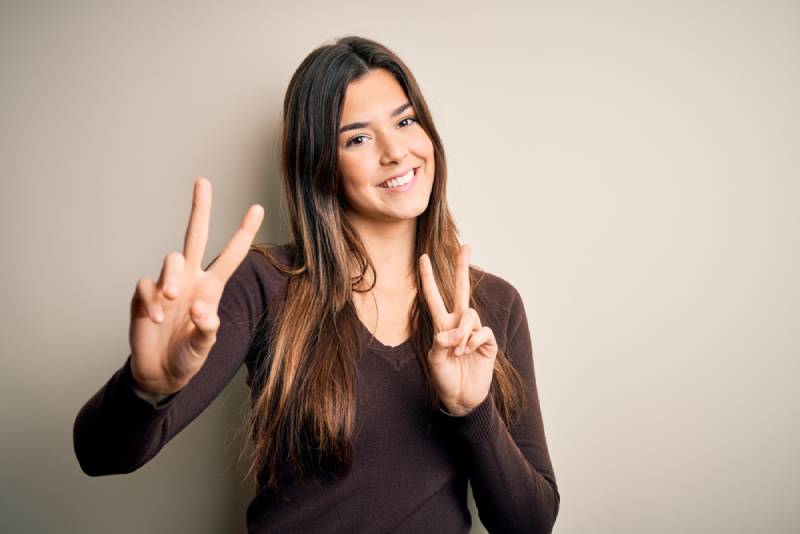 smiling woman showing peace sign