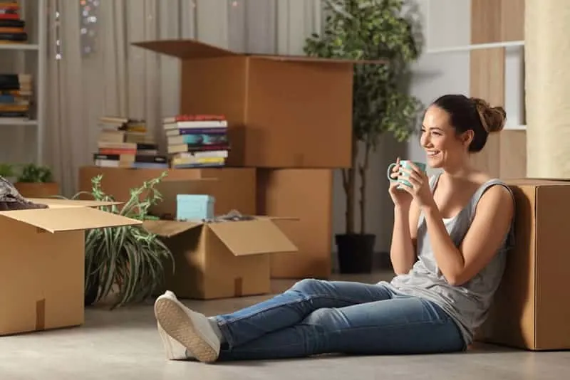 smiling woman sitting on floor at home