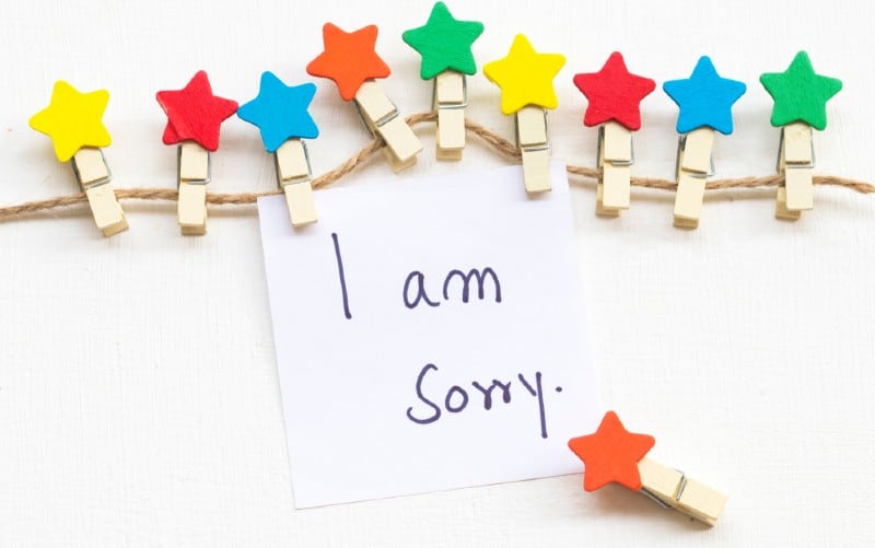 Colorful wooden star clips holding I am sorry note