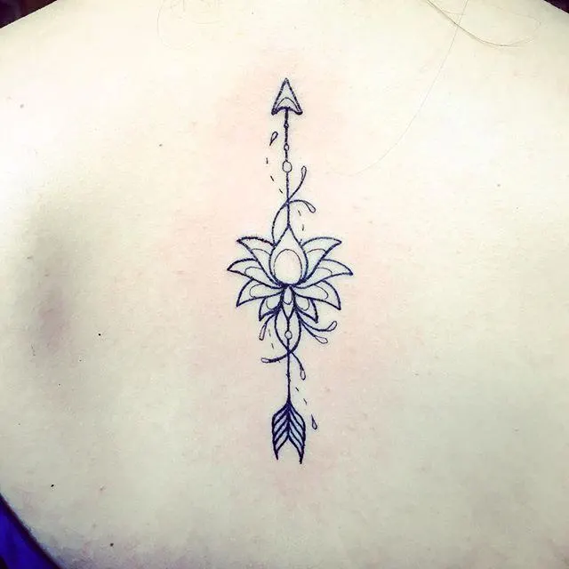 tattoo of a lotus arrow on spine line