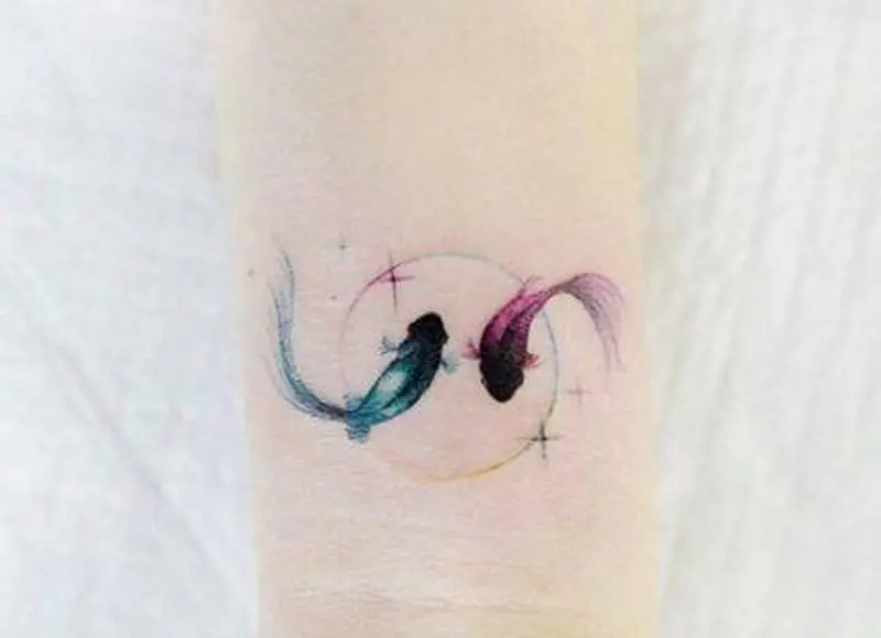 tattoo of blue and pink fish in the circle