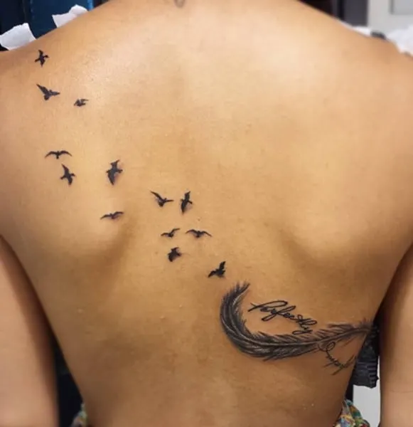 tatouage avec des oiseaux et une plume dans le dos