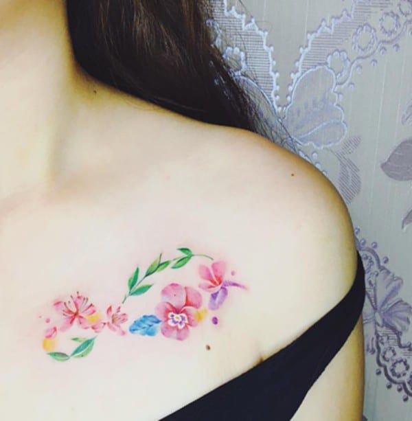 tattoo with botanical motifs under collarbone
