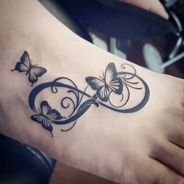 bold tattoo with butterflies and swirls on foot