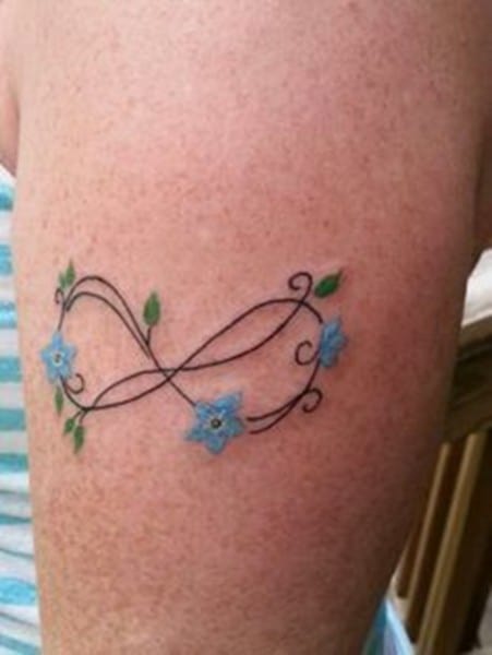 tatuaggio con fiori blu sul braccio