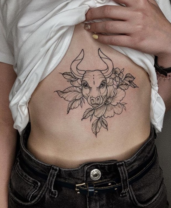taurus tattoo surrounded with flowers on the sternum