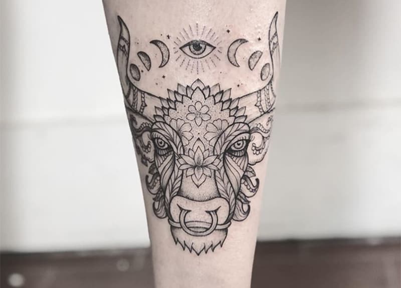 tatuaje de tauro con un ojo encima con diseño de flores