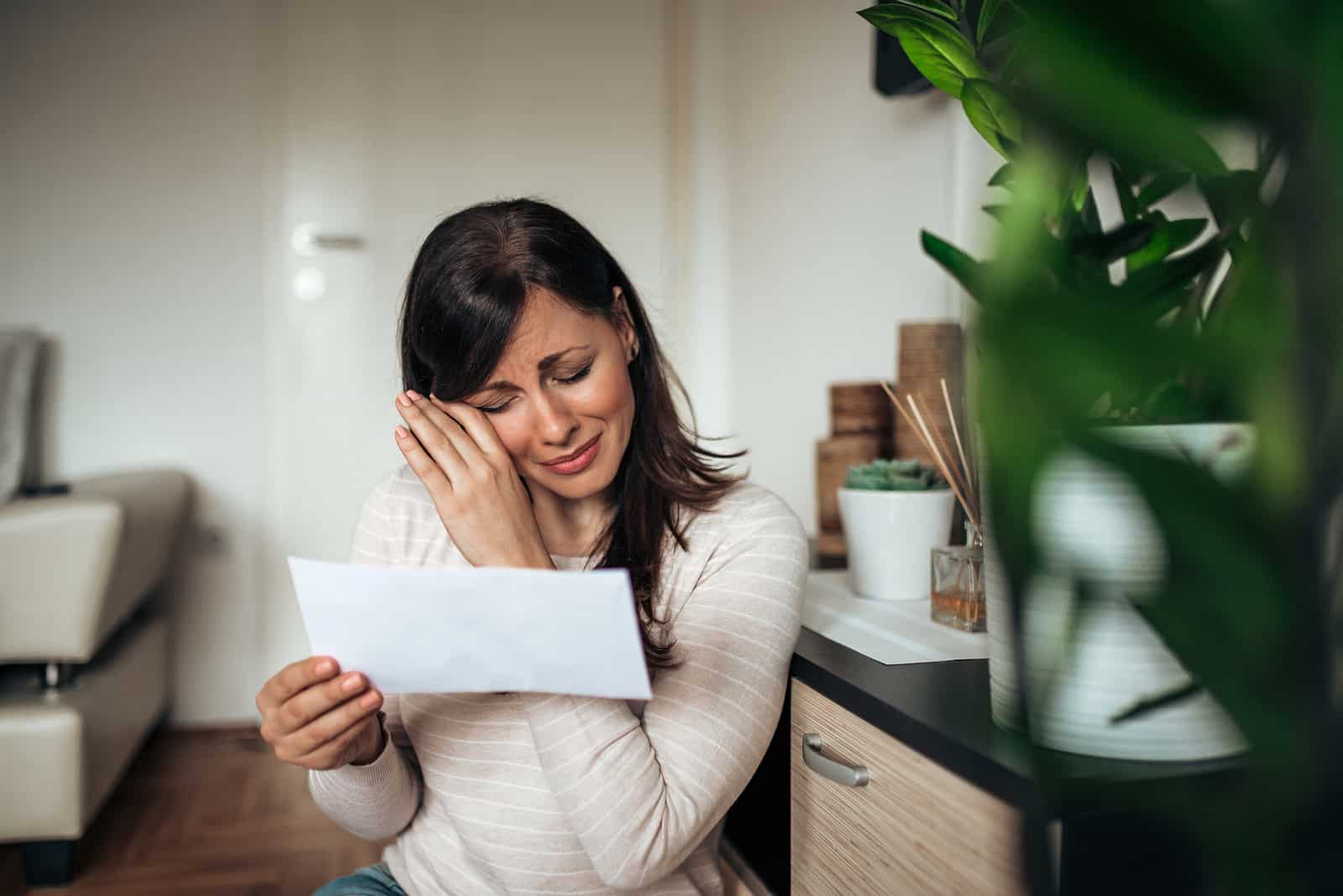 the woman sits reading the messages and laughs